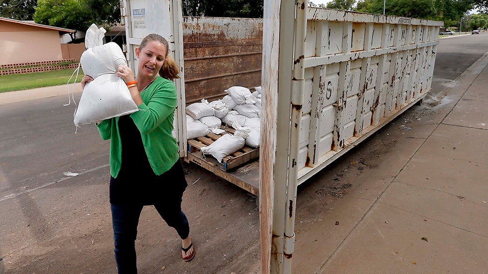 Stephanie Sunderhaus takes some free sandbags to protect her home, as remnants from Odile are forecast to bring heavy rains to parts of the U.S. Southwest. (AP Photo/Matt York)
