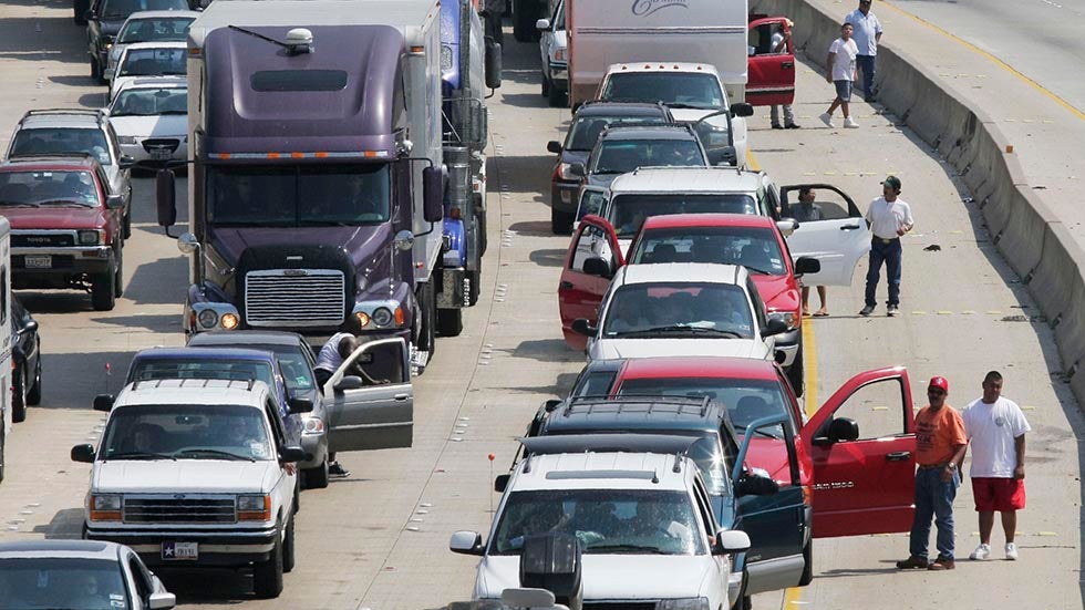Evacuees from Hurricane Rita stand outside their vehicles on Interstate 10 near downtown Houston, Sept. 22, 2005. Traffic was at a standstill as motorists moved just a few miles over a period of hours. (Dave Einsel/Getty Images)