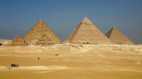 The three large pyramids of Menkaure (L), Khafre (C) and Khufu loom over the horizon November 13, 2004 at Giza, just outside Cairo, Egypt. The three large pyramids at Giza, built by King Khufu over a 30 year period around 2,550 B.C., are among Egypt's biggest tourist attractions. (Sean Gallup/Getty Images)