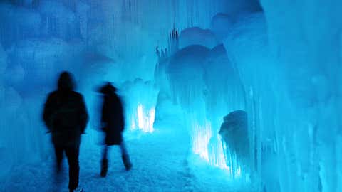 Patrons tour an ice castle at the base of the Loon Mountain ski resort in Lincoln, N.H. The ice castle begins to grow in the fall when the weather gets below freezing and thousands of icicles are made and harvested then placed around sprinkler heads and sprayed with water. (AP Photo/Jim Cole)