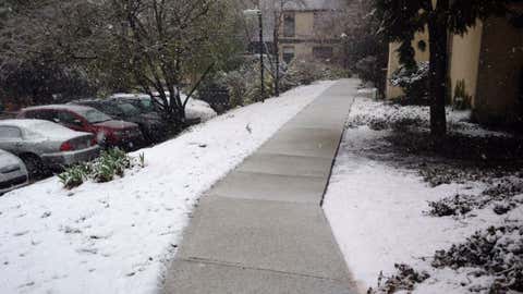 Snow falls on a sidewalk in Philadelphia, Pennsylvania, on April 9, 2016.