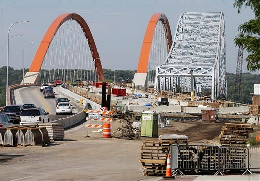 The partially dismantled old bridge remains at right as a work continues on the new bridge across the Mississippi River in Hastings, Minn. on Monday, Sept. 9, 2013. The two bridges show an aggressive push in Minnesota to deal with deteriorating bridges after the 2007 collapse in Minneapolis. (AP Photo/Jim Mone)