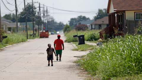 Bradli Noel, 9, right, and John Gibson, 4, walk in the street in the Lower Ninth Ward in New Orleans, Wednesday, Aug. 28, 2013. (AP/Gerald Herbert)