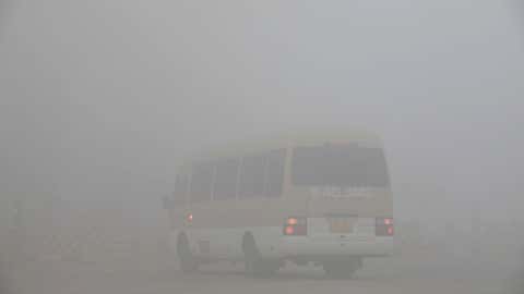 A bus is seen at a toll booth on a highway as vehicles are forced to wait due to heavy smog in Jilin, northeast China's Jilin province on October 22, 2013. (STR/AFP/Getty Images)