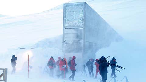 Journalists and cameramen walk under a gust of cold wind near the entrance of the Svalbard Global Seed Vault, officially opened near Longyearbyen, Norway, on Feb. 26, 2008. (Larsen, Hakon Mosvold/AFP/Getty Images)