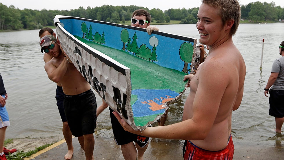 Members of the The University of Texas at Tyler concrete canoe team carry part their entry after it split during a race in theNational Concrete Canoe Competition in Homer, Ill., June 22, 2013. (AP Photo/Michael Conroy)