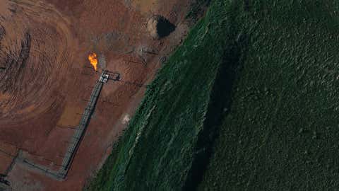 A flame burns off excess fuel at an oil drilling operation in the Bakken formation in western North Dakota. (Tristan Spinski)