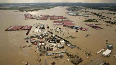 In this Aug. 30, 2017, photo, barges are secured by tugboats in the flood-swollen Burnet Bay along the Houston Ship Channel in Houston. (Tom Fox/The Dallas Morning News via AP)