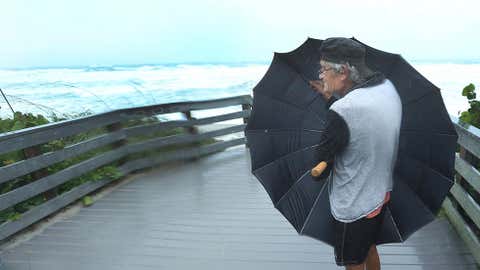 Patrick Danver, 67, of Satellite Beach, Fla. uses an umbrella to shield from the driving rain in South Patrick Shores, Fla., on Sept. 10, 2017 as Hurricane Irma made landfall in the state of Florida. (THE ASSOCIATED PRESS/Orlando Sentinel/Red Huber)