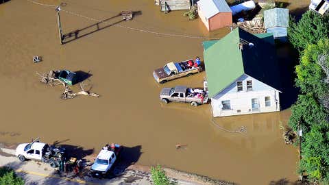 Victims of last week's devastating floods retrieve belongings outside a home near the East Platte River east of Greeley,Colo.,Tuesday,Sept. 17,2013. The area's broad agricultural flatlands were especially hard hit by the high water. (AP Photo/John Wark)