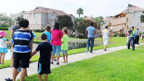 People stand near a partially collapsed building over a sinkhole at Summer Bay Resort near Disney World on Aug. 12, 2013 in Clermont, Florida. (Gerardo Mora/Getty Images)