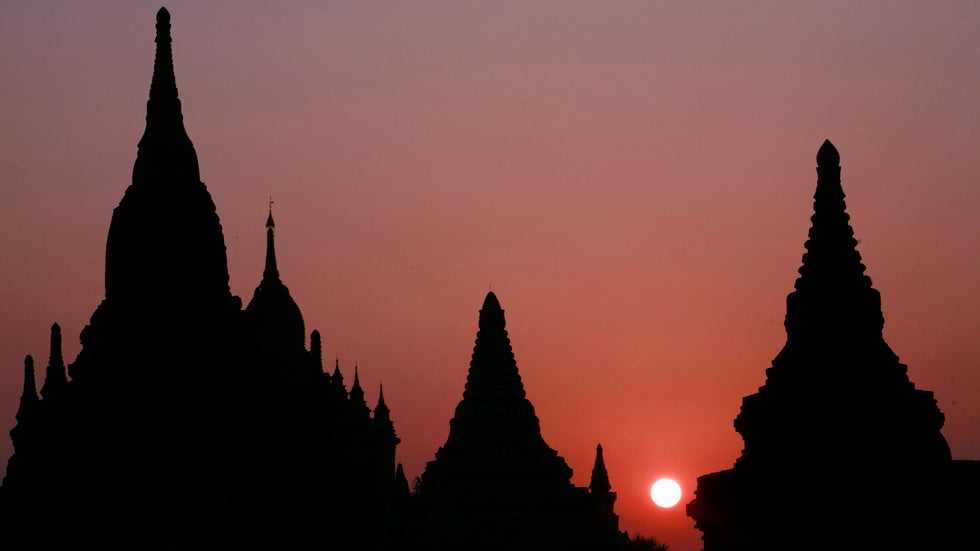 The sun rises next to an ancient temple Feb. 26, 2007 in Bagan, Myanmar. The 42 sq km plain of Old Bagan is dotted with some 3,000 ancient temples and is one of the key tourist attractions in Myanmar. (Paula Bronstein/Getty Images)