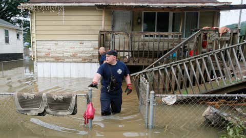 Bridgeport, West Virginia, fireman Ryan Moran exits a home as he and a crew search homes in Rainelle, W.Va., Saturday, June 25, 2016. Heavy rains that pummeled West Virginia left multiple people dead, and authorities said Saturday that an unknown number of people in the hardest-hit county remained unaccounted for. (AP Photo/Steve Helber)