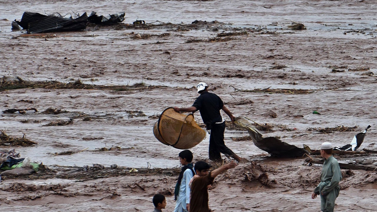 Floodwaters rush through a Pakistani market area as vendors and resident scramble to save their possessions on the outskirts of Peshawar on April 3, 2016. (A MAJEED/AFP/Getty Images)