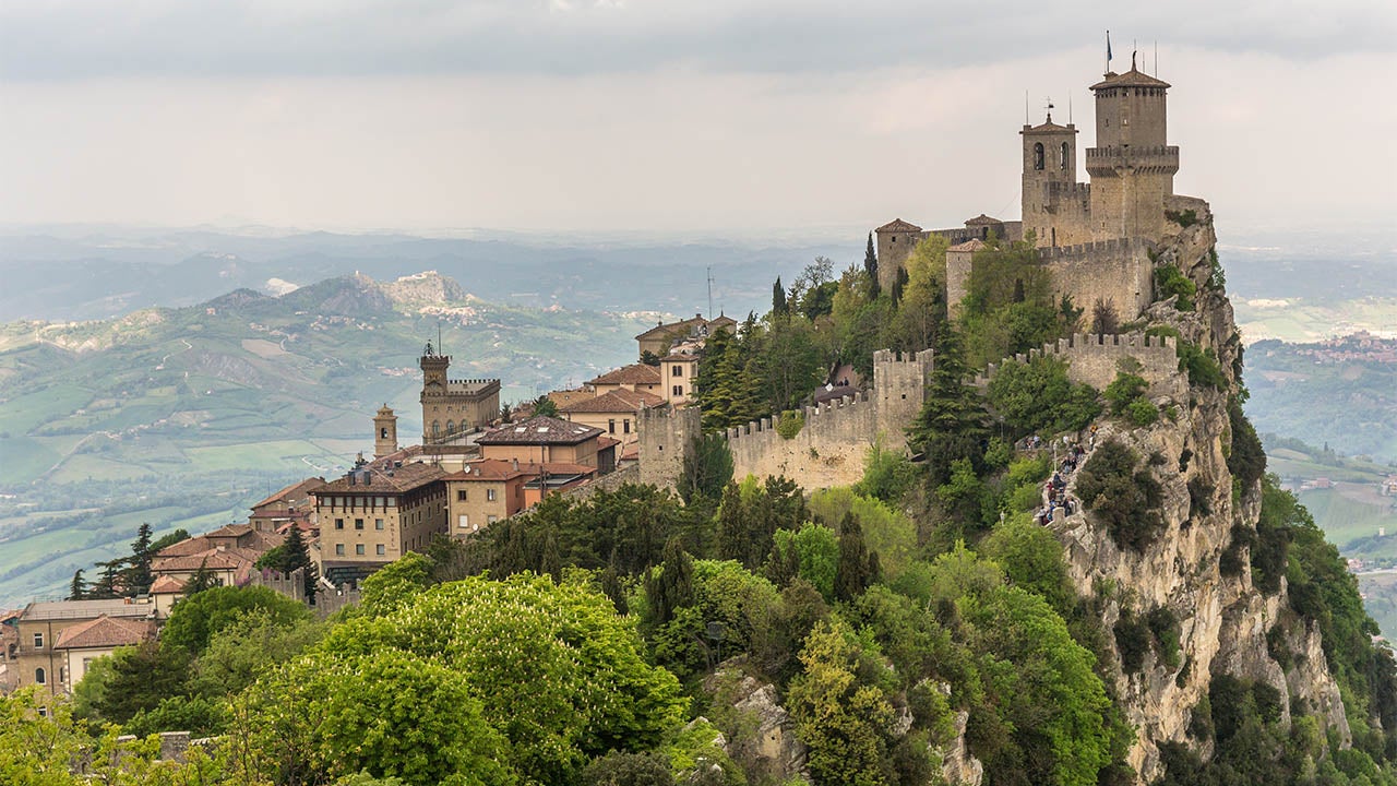 View of Guaita fortress (or First Tower) on top of Monte Titano in San Marino, and the surrounding hills. On the left the Palazzo Pubblico (Public Palace), the town hall of San Marino, can be seen. San Marino, April 2017. (Getty images)