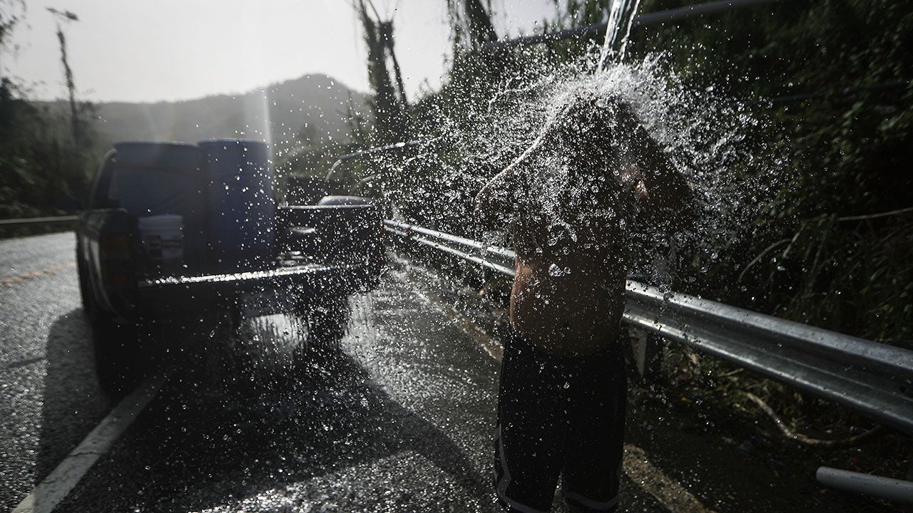 A man bathes with water funneled with pipes from a mountain stream, after filling barrels of water for his home, nearly one month after Hurricane Maria struck on October 19, 2017 in Utuado, Puerto Rico. Puerto Rico is suffering shortages of food and water in areas with only 21.6 percent of grid electricity and 71.58 percent of running water restored. Puerto Rico experienced widespread damage including most of the electrical, gas and water grid as well as agriculture after Hurricane Maria, a category 4 hurricane, swept through.  (Mario Tama/Getty Images)