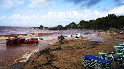 Abandoned cars are piled into the sea after being washed away by torrential rainfall and flooding in Greece on Sept. 7, 2016.