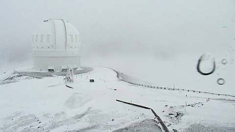 In this image made from webcam video provided by Canada-France-Hawaii Telescope, the CFHT telescope on the summit of Mauna Kea on Hawaii's Big Island is covered in snow on Thursday, Dec. 1, 2016. (Canada-France-Hawaii Telescope via AP)