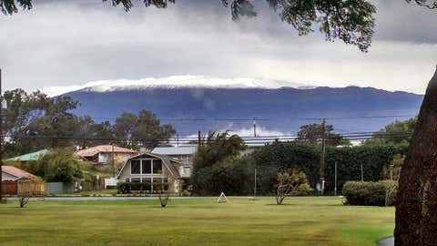 This photo provided by Grant Matsushige, an Instrumentation Specialist at the Canada-France-Hawaii Telescope, shows the summit of Mauna Kea on Hawaii's Big Island covered in snow as seen from Waimea, Hawaii on Thursday, Dec. 1, 2016. (Grant Matsushige/Canada-France-Hawaii Telescope via AP)