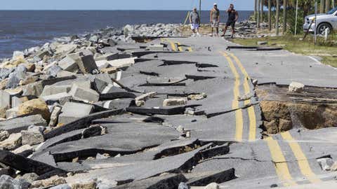 Residents look at Alligator Point road that collapsed during the storm surge from Hurricane Hermine at Alligator Point, Florida on September 2, 2016. Hermine made landfall as a Category 1 hurricane but has weakened back to a tropical storm.