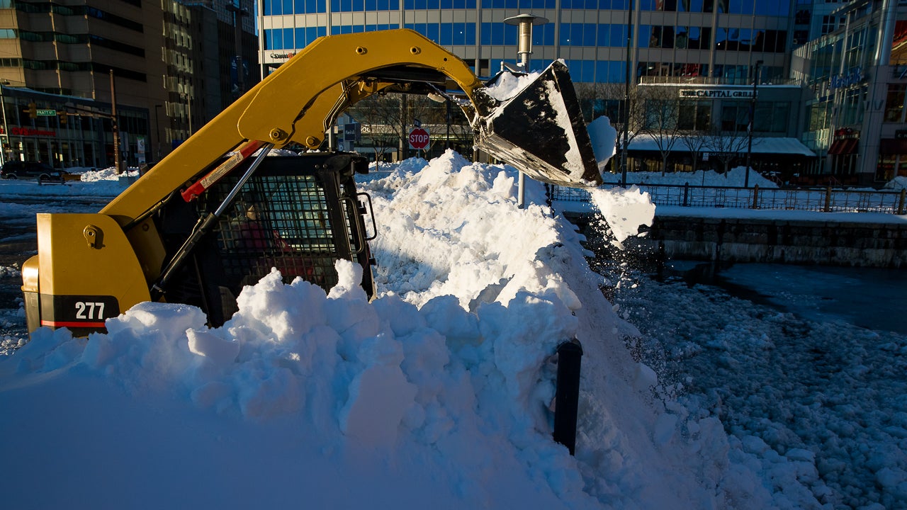 A worker using a skid steer loader dumps snow into the Chesapeake Bay a day after Winter Storm Jonas dropped nearly 30 inches of snow in Baltimore, Maryland on Sunday, January 24, 2016. (Shawn Hubbard/weather.com)