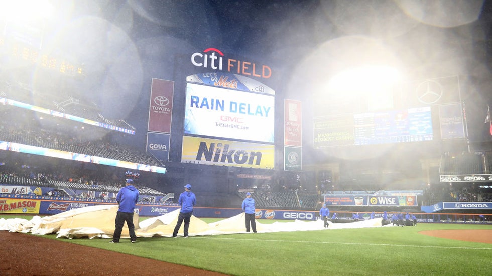 The grounds crew pulls the tarp on the field in the third inning as the rain causes a delay in the game between the New York Mets and the Miami Marlins on May 6, 2017 at Citi Field in the Flushing neighborhood of the Queens borough of New York City. (Photo by Elsa/Getty Images)
