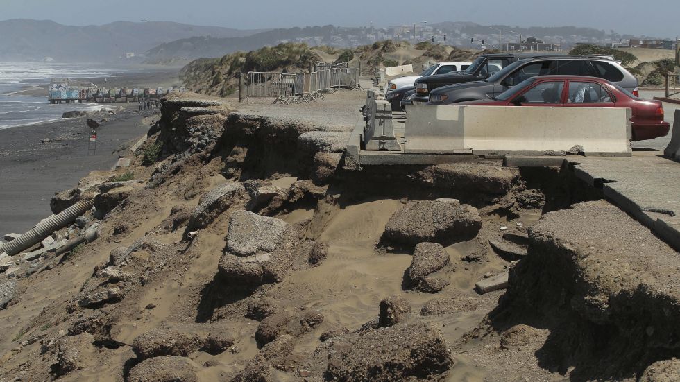 Coastal erosion at Ocean Beach, California parking lot.