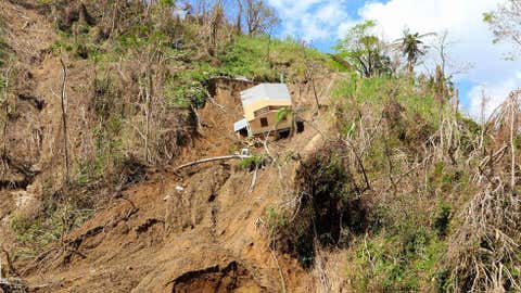 A home is shown partially swept down a hillside in the municipality of Corozal,Puerto Rico,on October 4,2017,two weeks after Hurricane Maria ravaged the U.S. territory. Over 15 families were isolated by this landslide. (Sg. Alexis Vélez/Released-PAO)