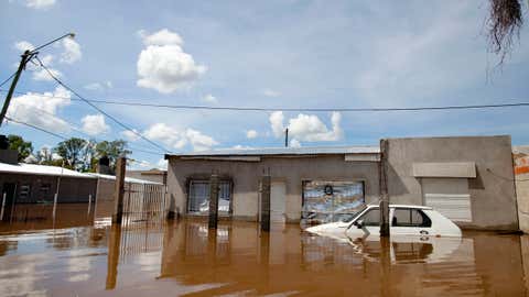 A car and homes are submerged in flood water in Concordia, Argentina, Monday, Dec. 28, 2015. At least 20,000 have been evacuated in Argentina. Neighboring Paraguay has been hardest hit, with 100,000 evacuating. Several thousand have also been evacuated in Uruguay and southern Brazil. (AP Photo/Natacha Pisarenko)