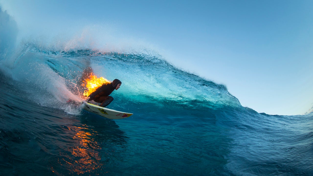 Jamie O'Brien surfs while lit on fire, in Teahupoo, Tahiti on July 21, 2015. (Ben Thouard/Red Bull Content Pool)