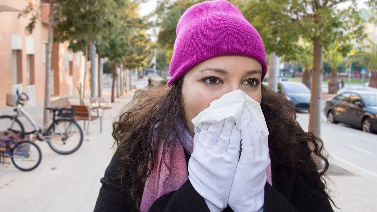 woman with a great cold sneezes with a tissue in her hands
