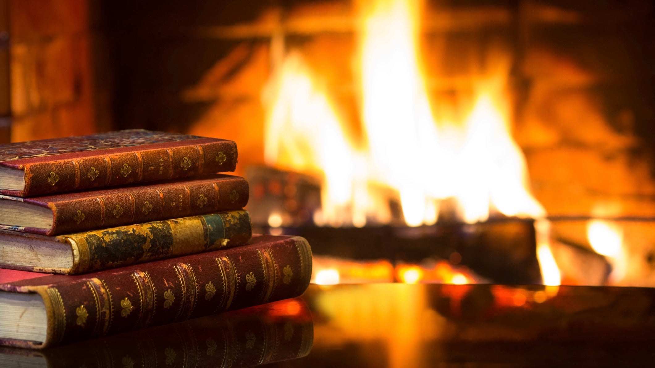 Antique books in front of warm fireplace. Magical relaxed cozy atmosphere near fire.