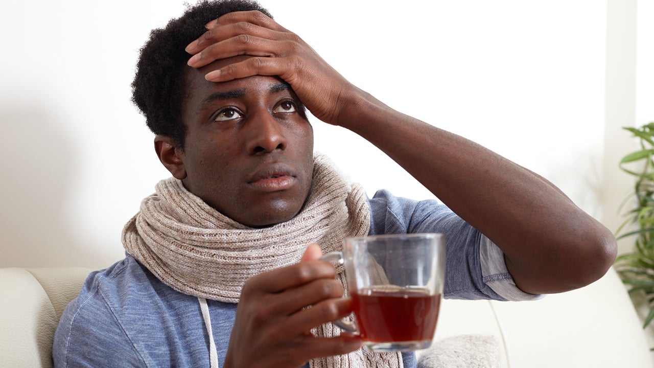 sick african american young man drinking hot tea