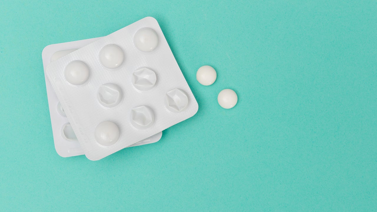 Medicine in blister packaging and two white round pills