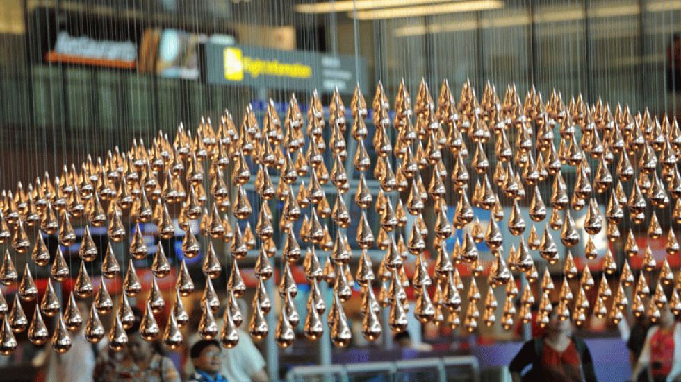 A view of 'Kinetic Rain,' a kinetic art sculpture made of 600 copper-plated rain droplets in Singapore's Changi Airport Terminal 1.  Computer-controlled motors raise and lower the droplets, forming various shapes. (Photo: Roslan Rahman/AFP/Getty Images) 