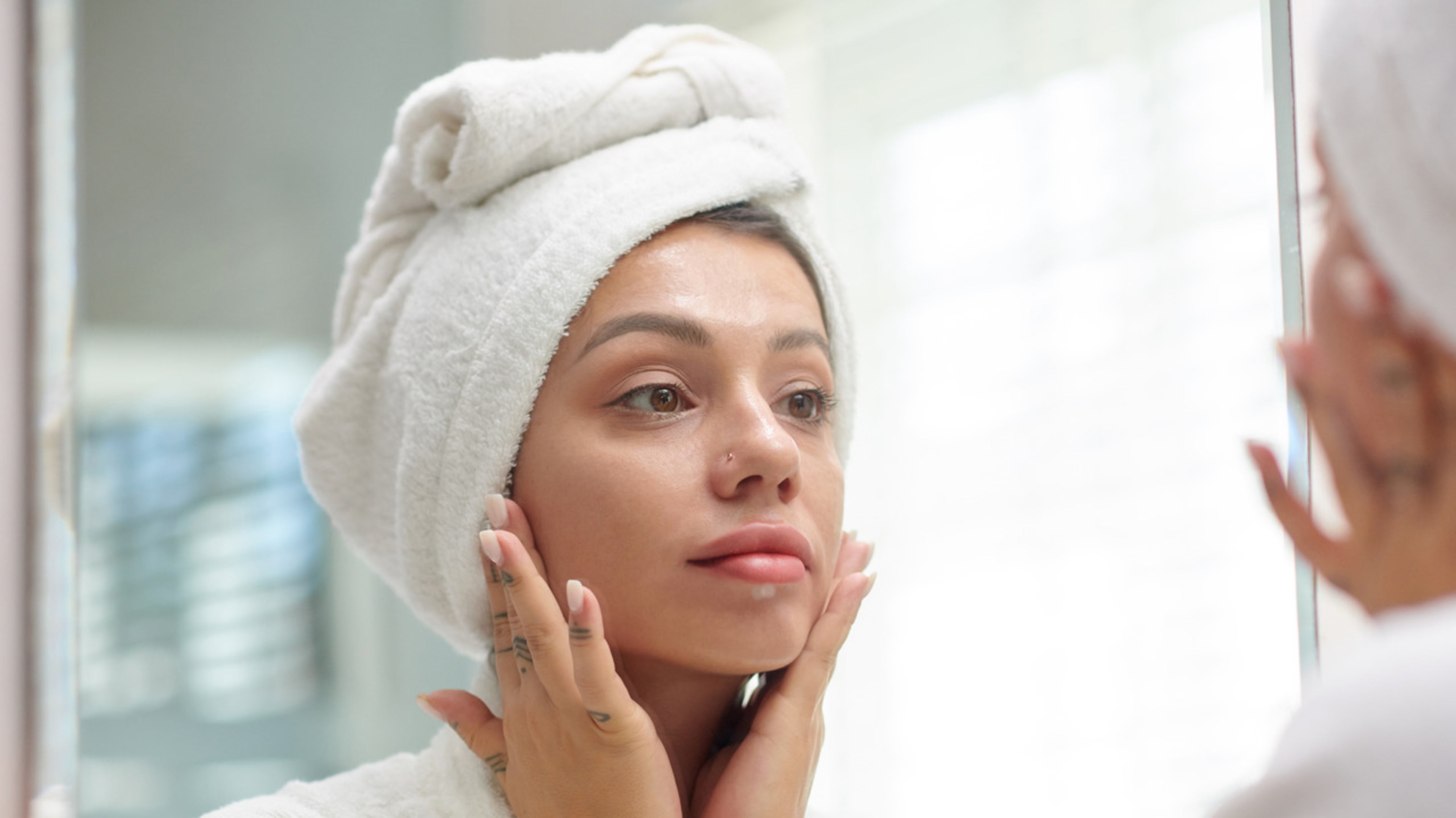 Woman in bathrobe looking in mirror