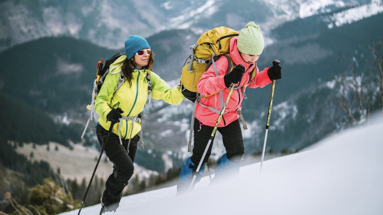 Two people climbing up mountain in winter