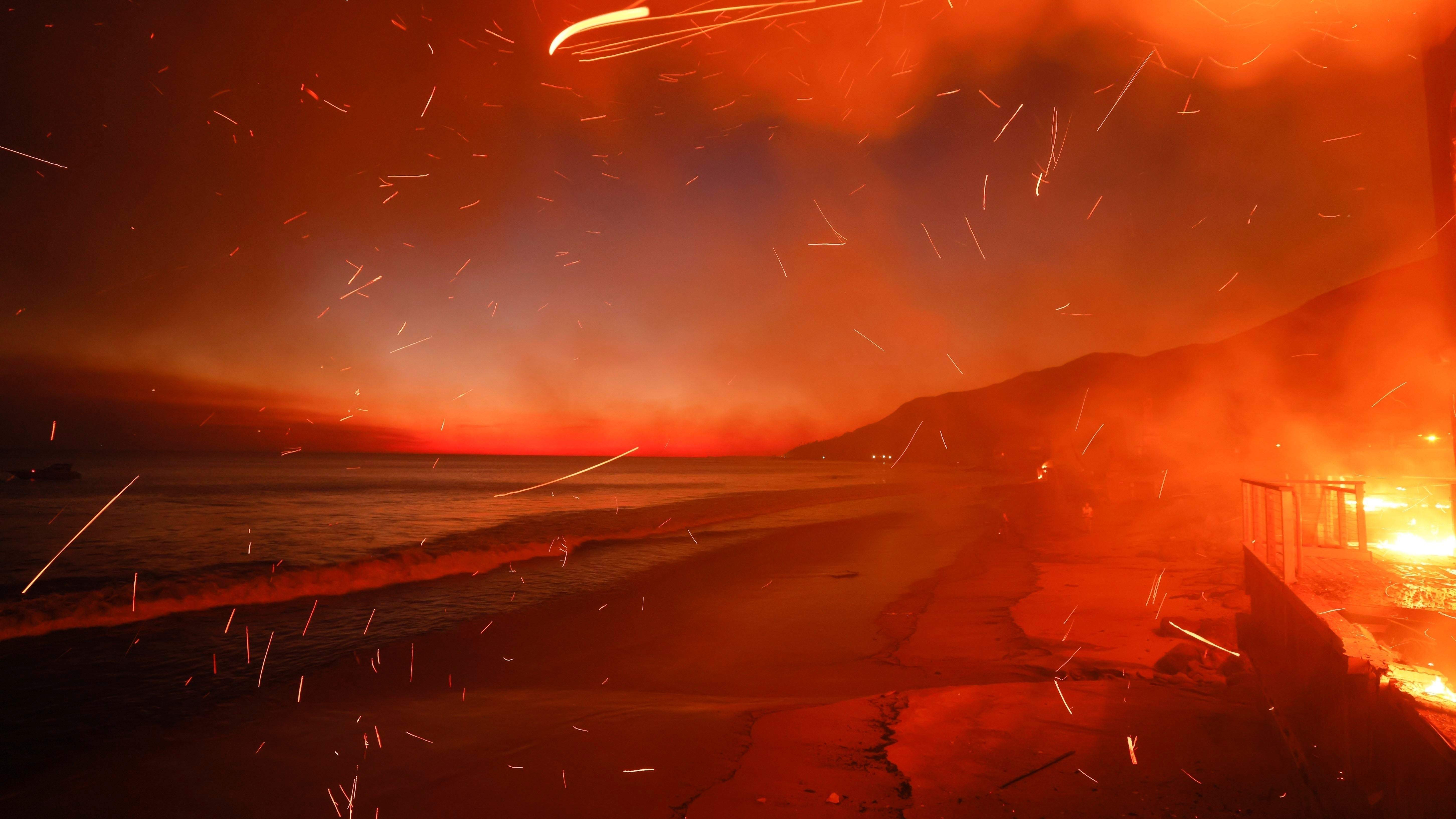 Smoke and embers fly across a red fiery sky.