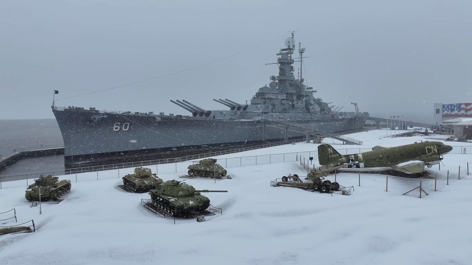 Snow falls on the retired battleship and aircraft at the USS Alabama Battleship Memorial Park in Mobile, Alabama on Tuesday, January 21, 2025