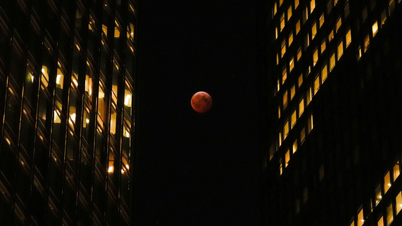 Red moon seen between two buildings in Chicago during a total lunar eclipse
