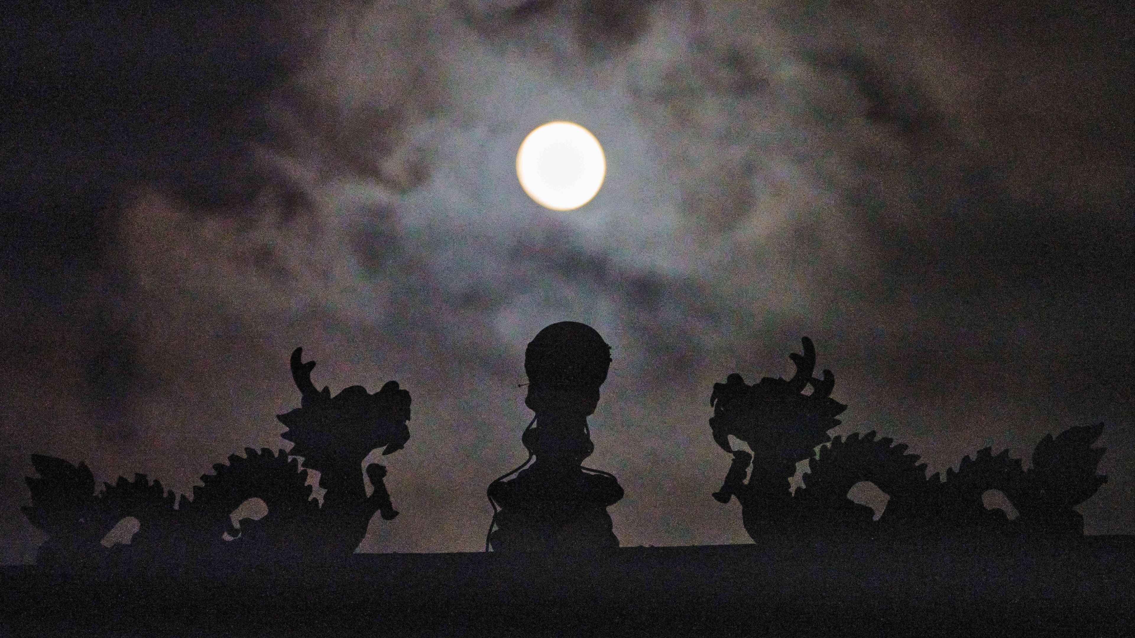 The harvest supermoon rises on the Tau Tau temple in Los Angeles of Chinatown.