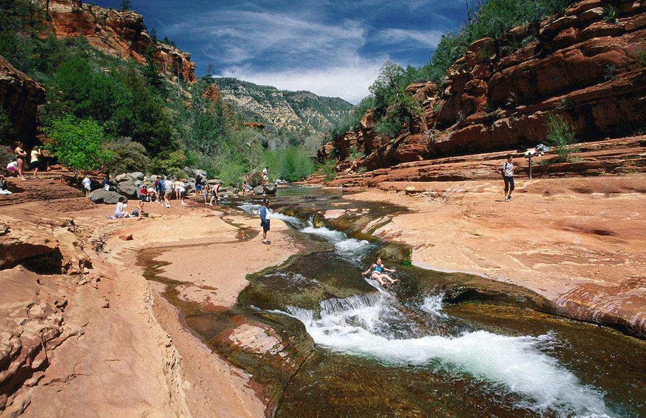 A person slides down the natural water slide at Slide Rock State Park in Arizona.