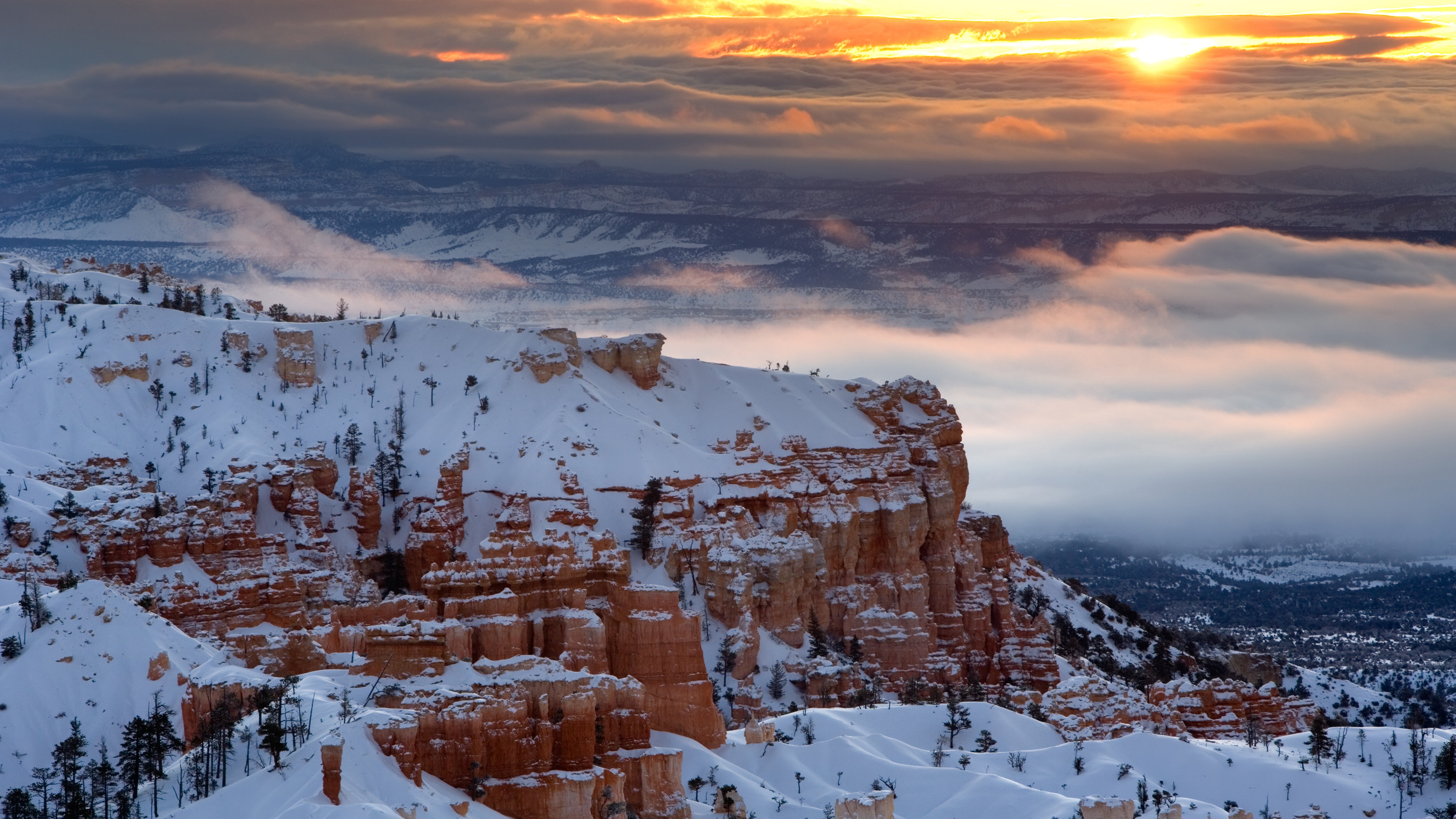 Sunrise over misty clouds hanging in the valley of Bryce Canyon National Park.