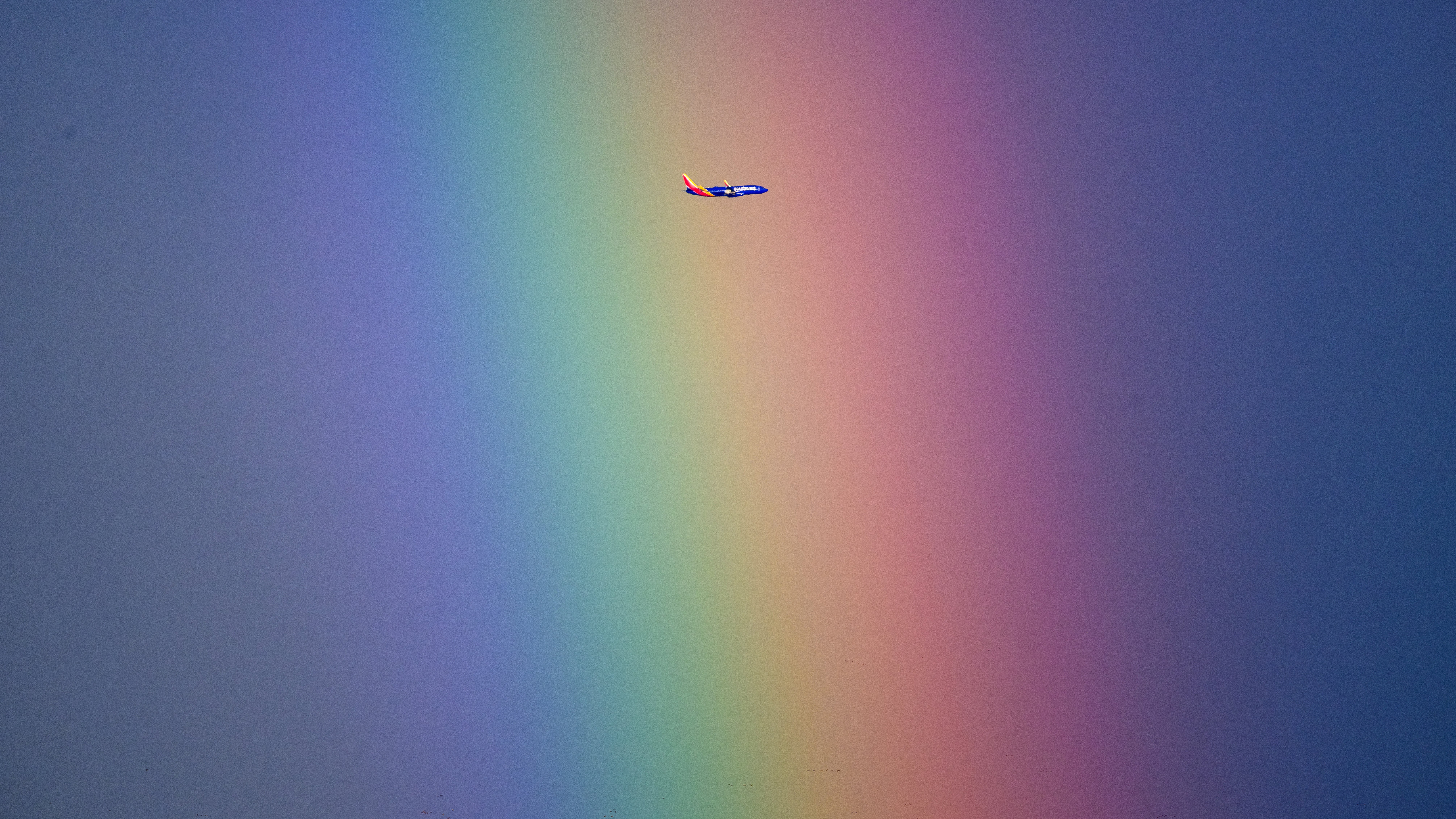 A Southwest Airlines plane flies through a rainbow.