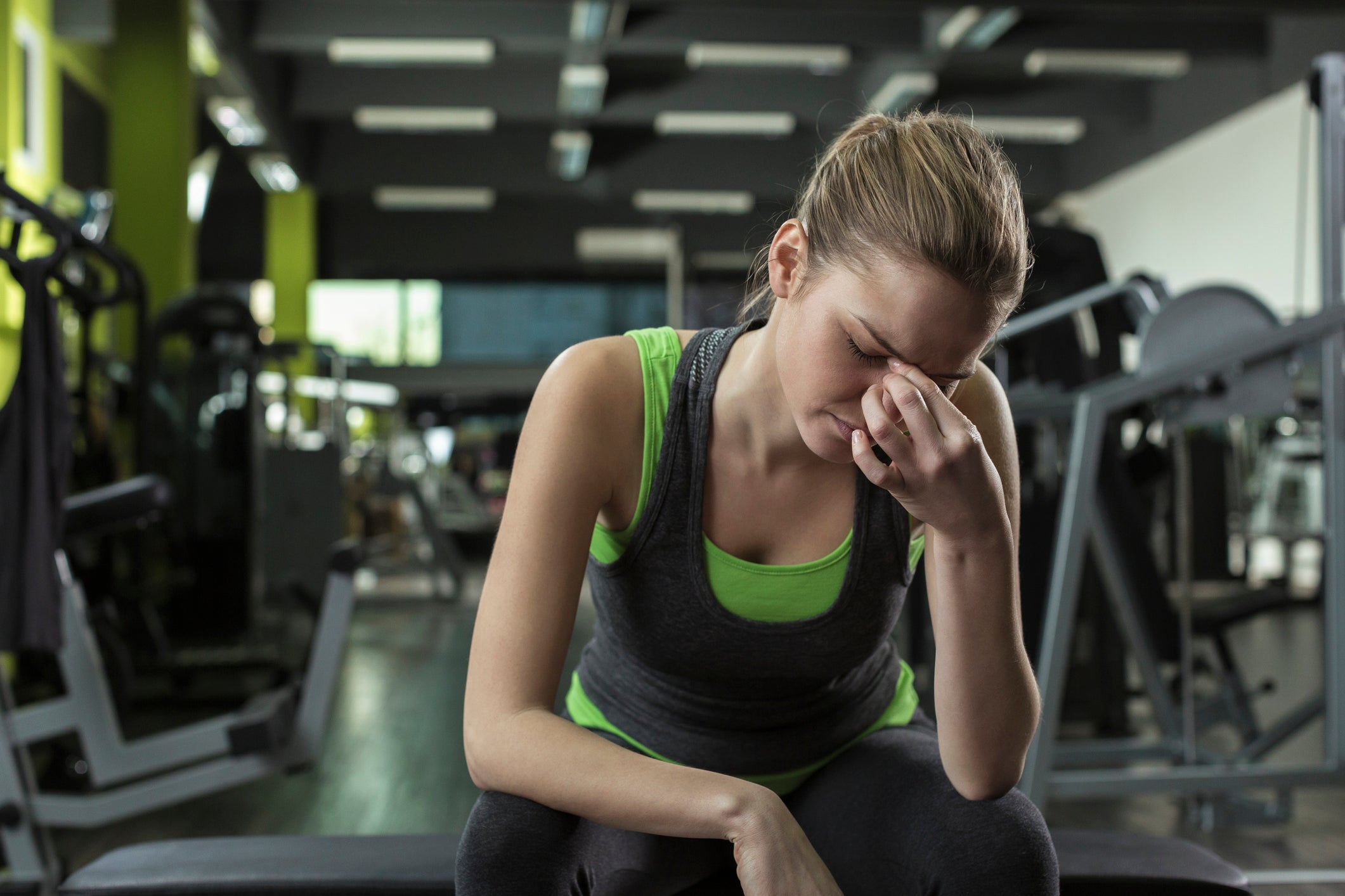 Woman with migraine at the gym