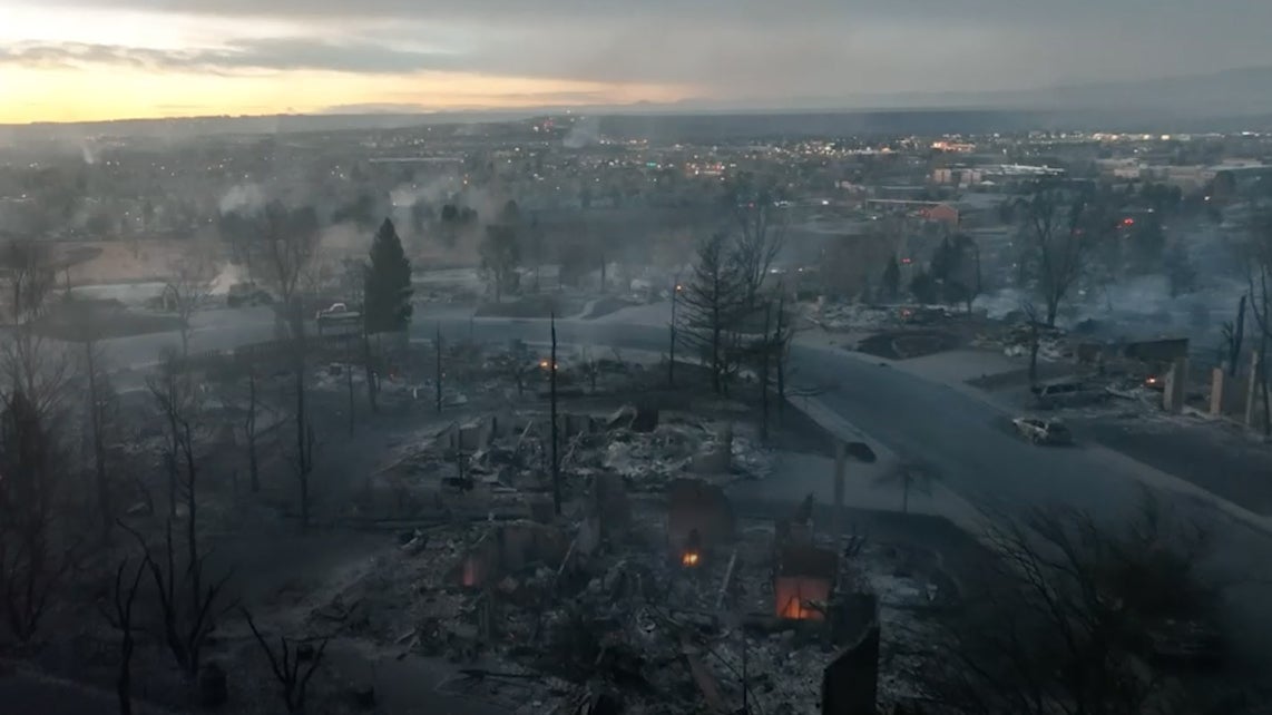 This screen shot from a drone video shows smoldering ruins of a neighborhood in Louisville, Colorado.