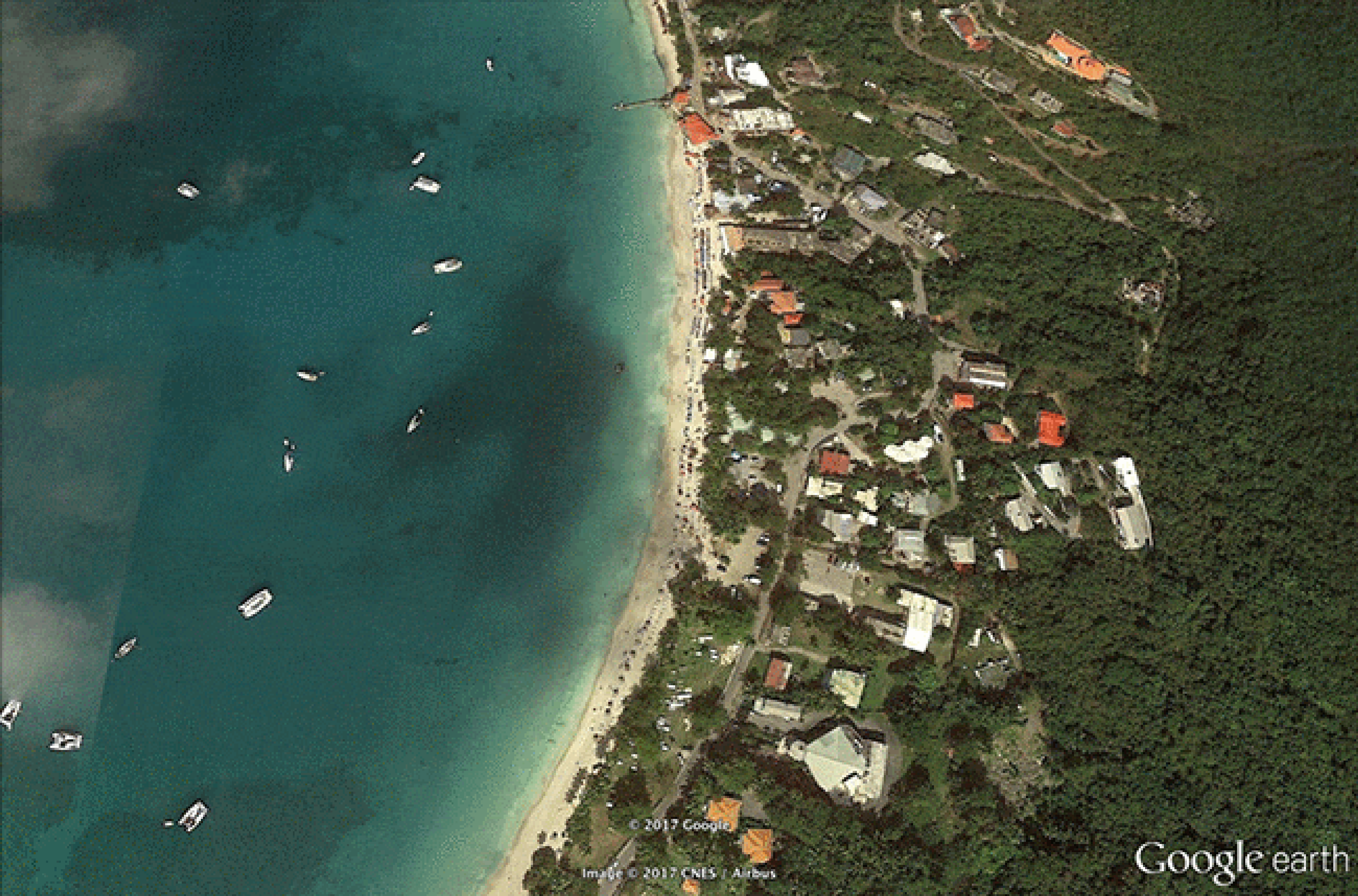 Before/after images of damage from Hurricane Irma in Cane Garden Bay Beach on Tortola in the British Virgin Islands, in September 2017. The white arrow highlights an area where the surge pushed beyond the first row of buildings at the beach.