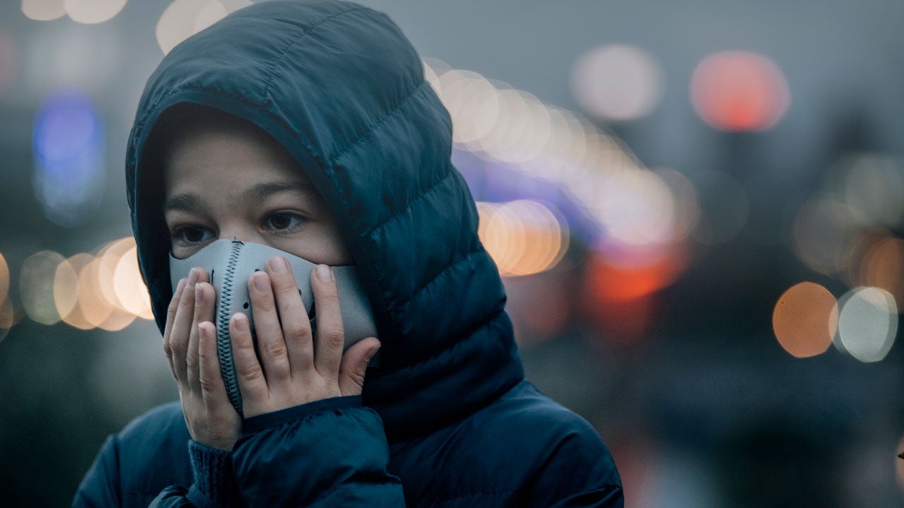 Child in mask dealing with poor air quality