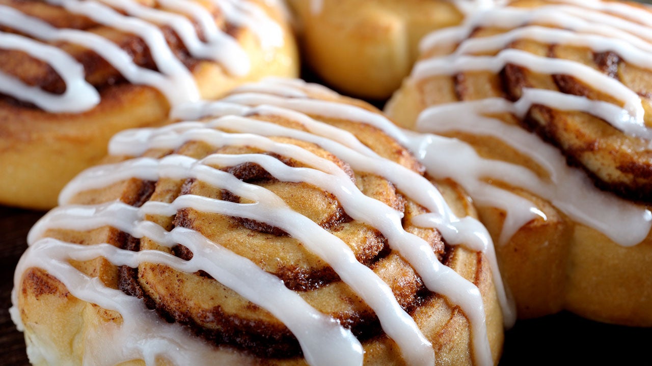 several cinnamon rolls with icing on a plate