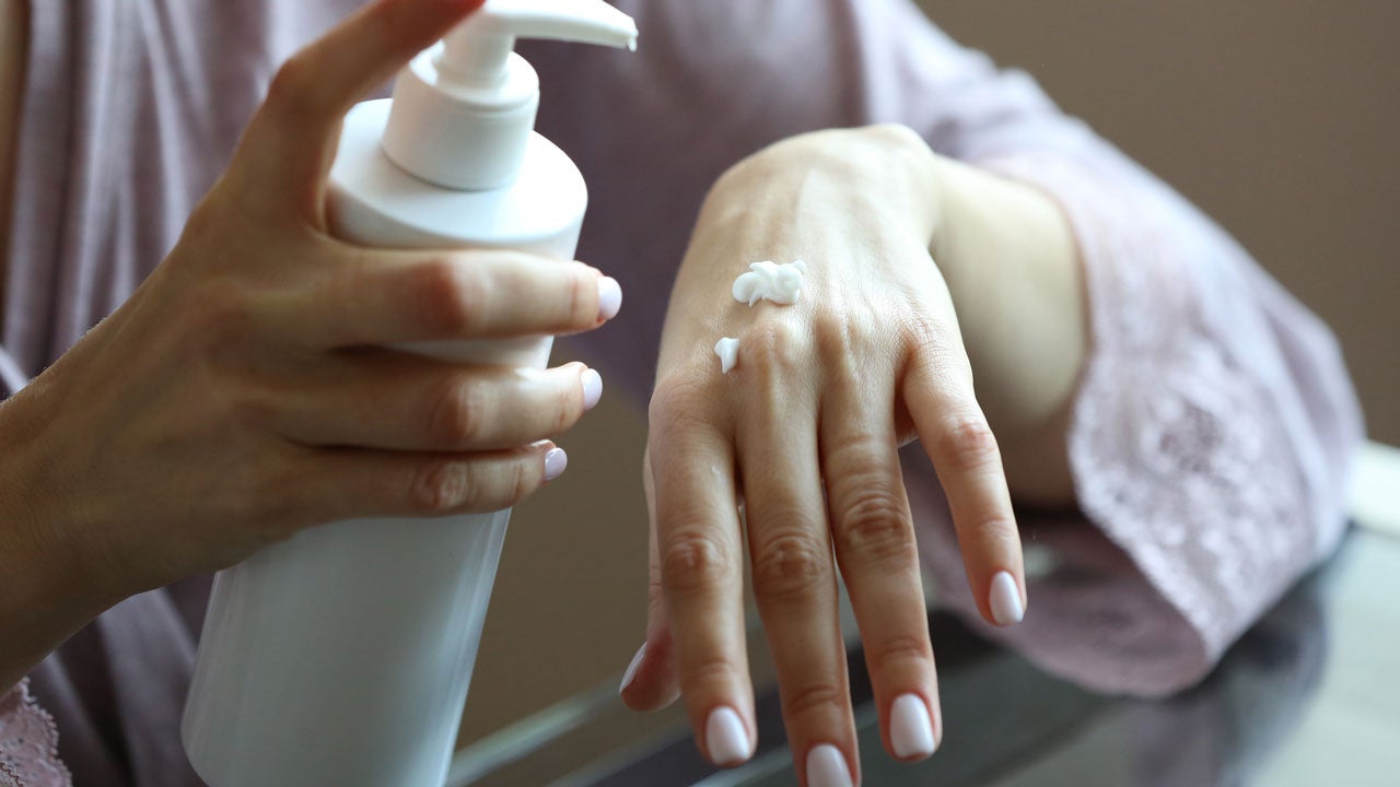Woman holding lotion bottle